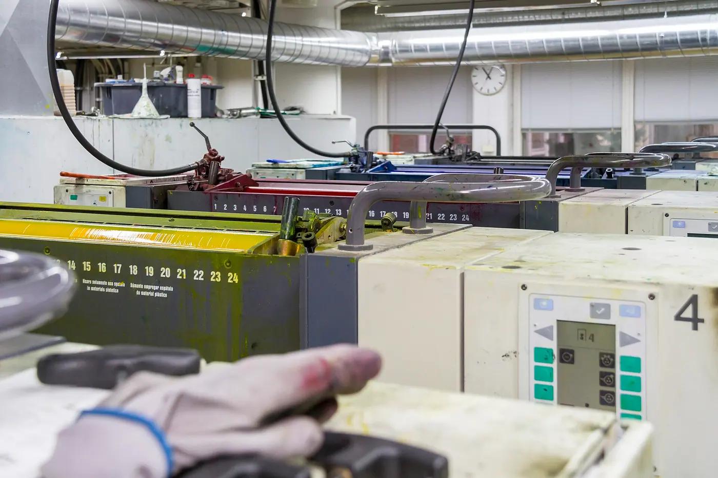 Ink units of an offset printing press showing yellow, magenta and cyan sections