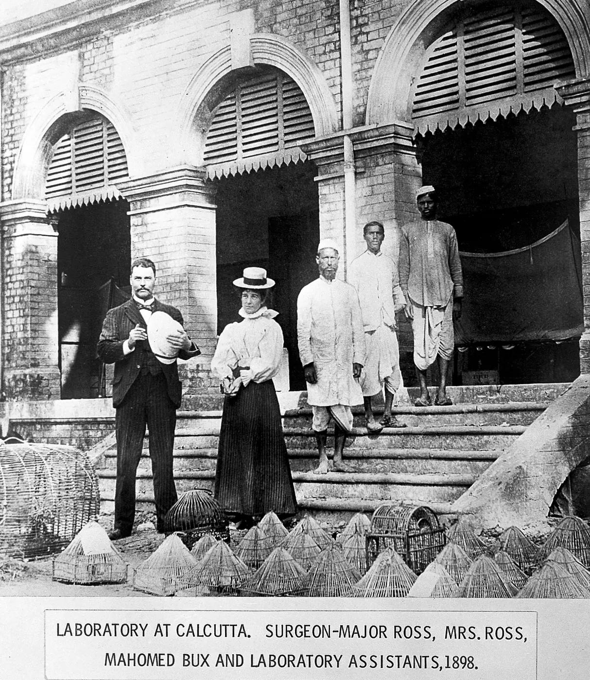 Ronald Ross, his wife and laboratory assistants including Mahomed Bux on the steps of the Calcutta laboratory in 1898, with bird cages in front