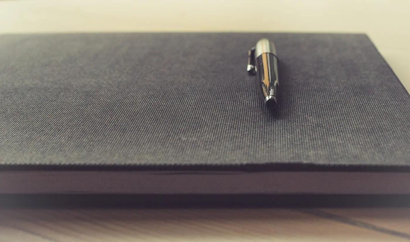 Notebook and pen on a wooden table
