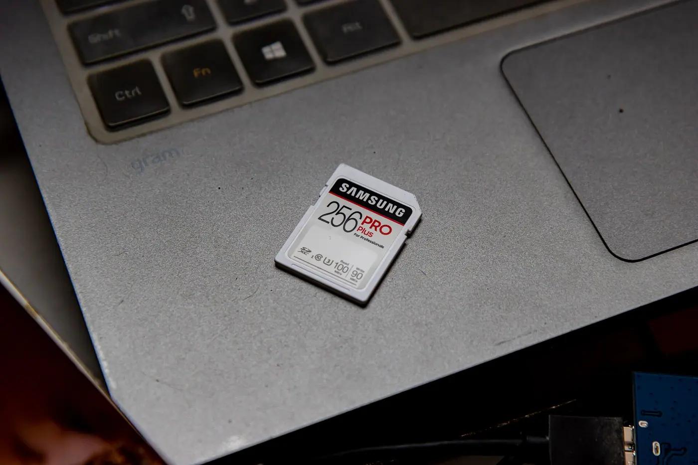 An SD memory card lying on a laptop keyboard